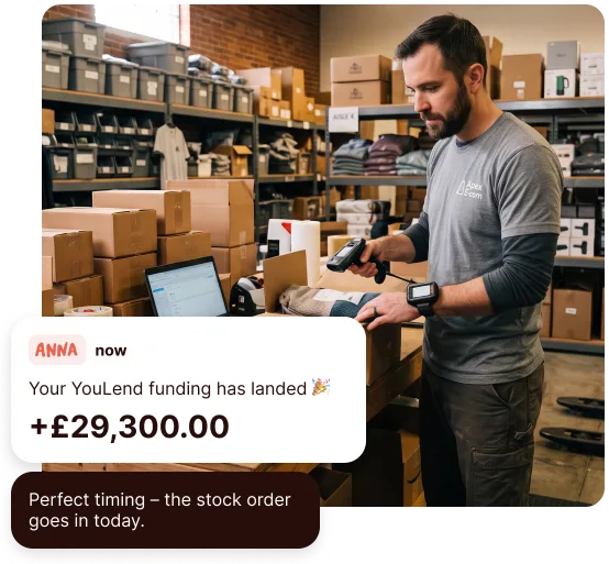 Small business owner scanning stock in a warehouse, with an ANNA notification that £29,300 of YouLend funding has landed