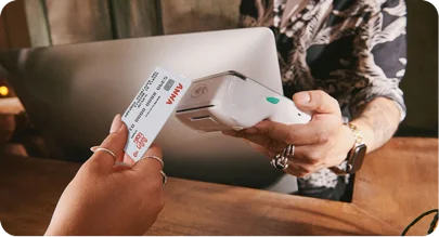 Customer tapping a contactless card on a Dojo card terminal partnered with ANNA