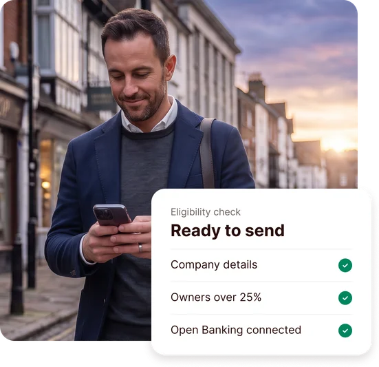 Business owner checking the ANNA app on his phone in the high street, with a merchant cash advance eligibility check showing company details, owners over 25% and Open Banking connected, ready to send