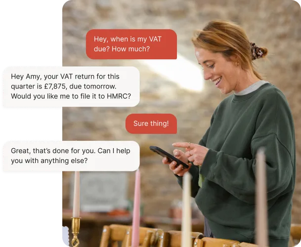 Smiling sole trader using her phone to chat with Auto Accountant, which tells her the VAT return is £7,875, due tomorrow, and files it to HMRC when she replies ‘Sure thing!’